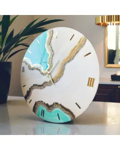 ساعة حائط مصنوعة يدويًا من الريزن الإيبوكسي بألوان عاجية وفيروزية أنيقة ومزينة بالكريستال لتكون قطعة ديكور لافتة.